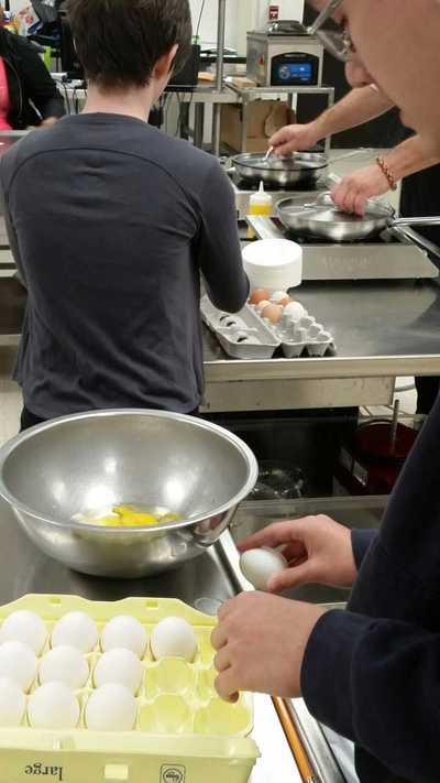 student mixing up eggs