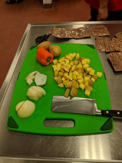 Cutting board with knife and items cut up.