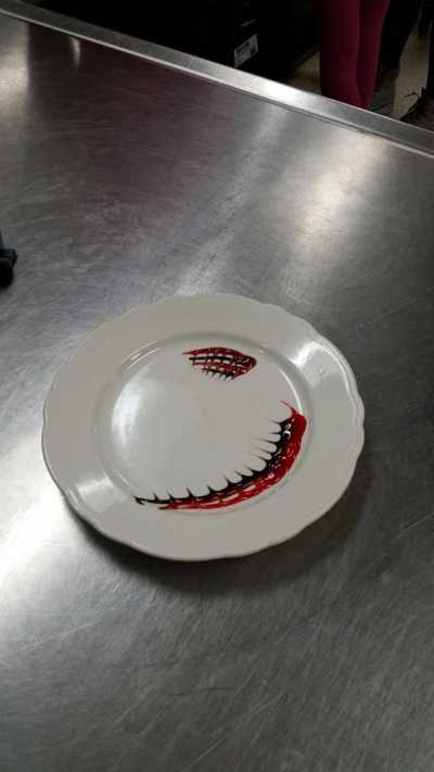 chocolate and strawberry sauce used to decorate a plate in what looks to be small sharklike teeth