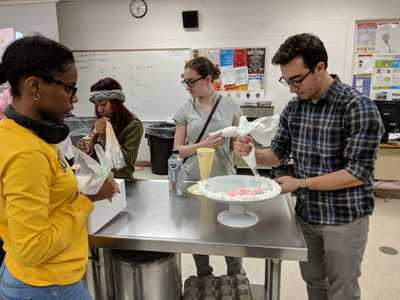 Students creating the platter decorated with buttercream roses.