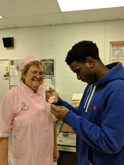 Chef Ele' Shepherd assisting a student to create their buttercream rose.