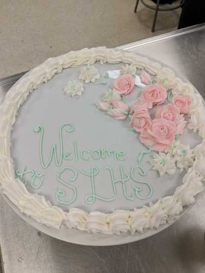 Platter decorated with "Welcome SLHS" with buttercream roses.  