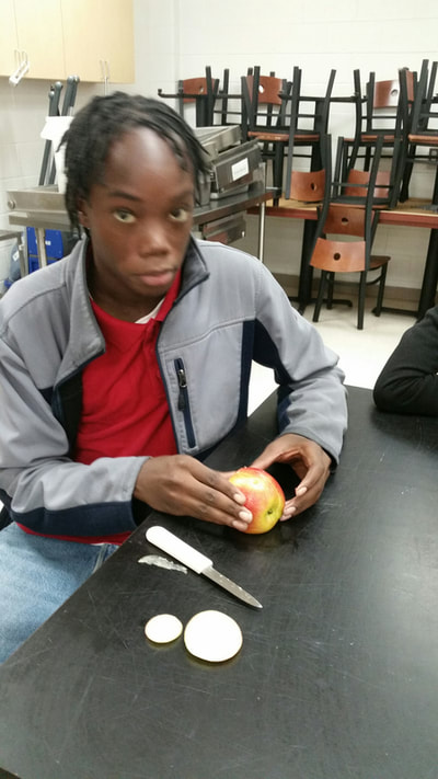 Culinary 3 and 4 student working to complete his apple swan.  