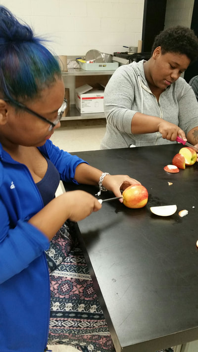 Culinary 3 and 4 student creating an apple swan.  