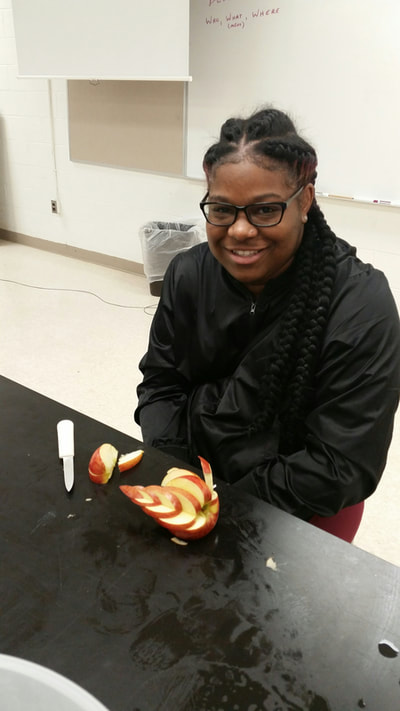 Culinary 3 and 4 student posing with completed apple swan.  