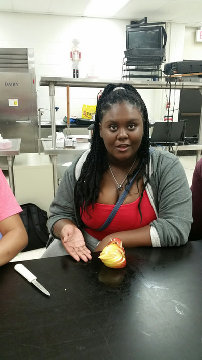 Culinary 3 and 4 student posing with completed apple swan.  