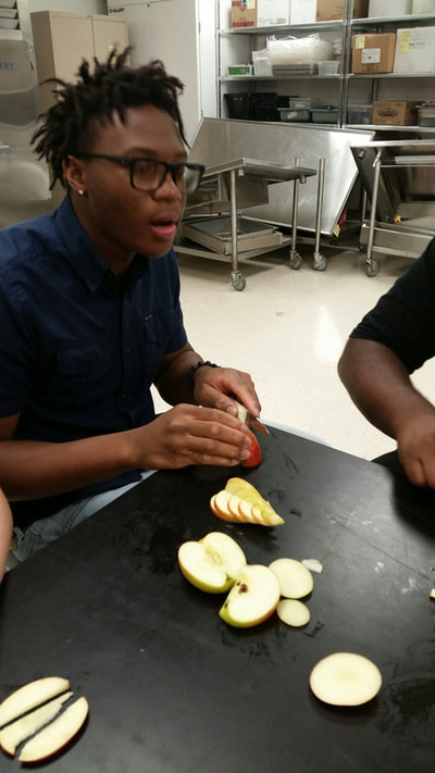 Culinary 3 and 4 student working on his apple swan.