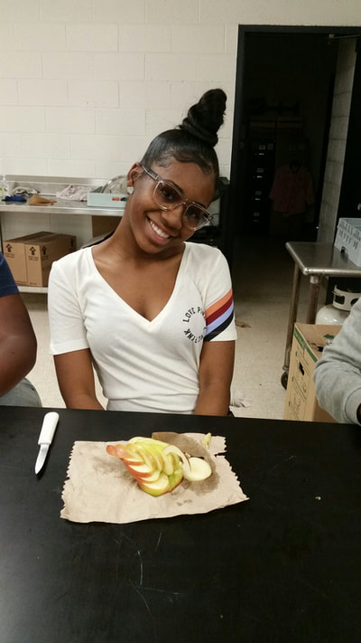 Culinary 5 and 6 student posing with completed apple swan.
