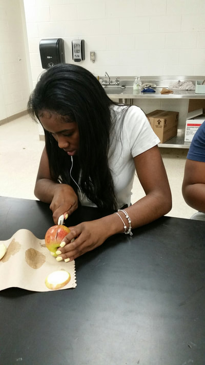 Culinary 3 and 4 student working on creating an apple swan.  