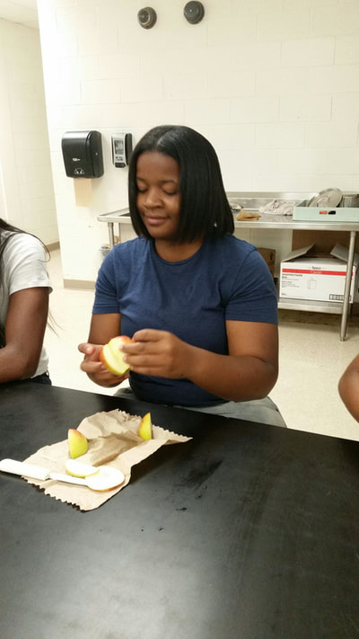 Culinary 3 and 4 student working on creating an apple swan.  