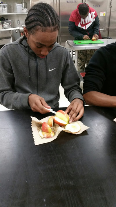Culinary 5 and 6 student working on creating an apple swan.  