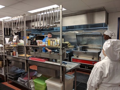 Chef Shepherd in back of the house (kitchen) directing student chefs.