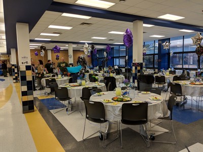 Picture of multiple tables, dressed and ready for event.