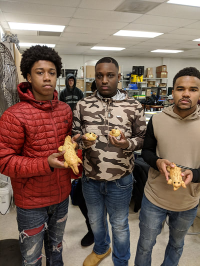 Three students posing with their bread animals.