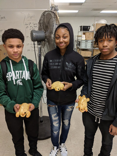 Three students posing with their bread animals.

