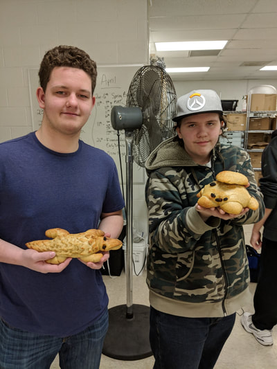 Two students posing with their bread animals.
