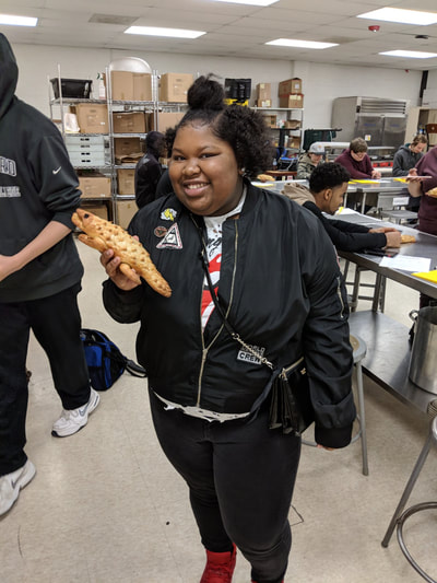 Student posing with her bread animal.