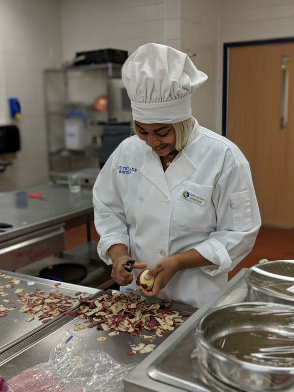 Student chef peeling potatoes.
