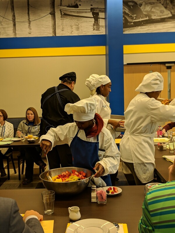 Student chef serving fruit.