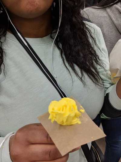 Female student displaying her yellow buttercream frosting rose.