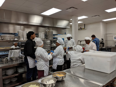 All Culinary Arts students who volunteered gather for a briefing by Chef
