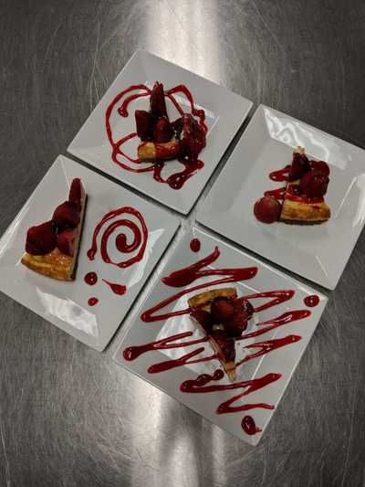 four plates dressed with strawberry cheesecake
