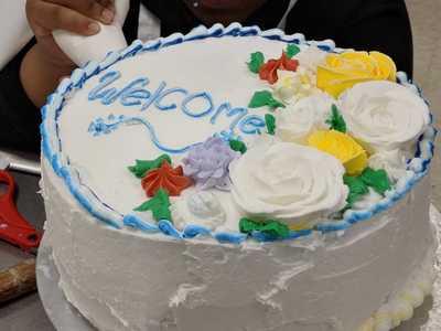 Picture of a cake decorated by all students with Welcome on top.