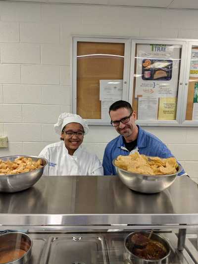Principal, Mr. Beato and student chef smiling and posing for picture.