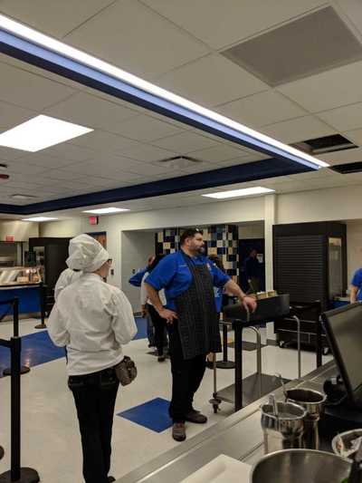 Chef Shepherd monitoring student chefs in the cafeteria serving area.