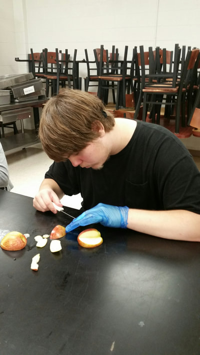 Foods student creating an apple swan.