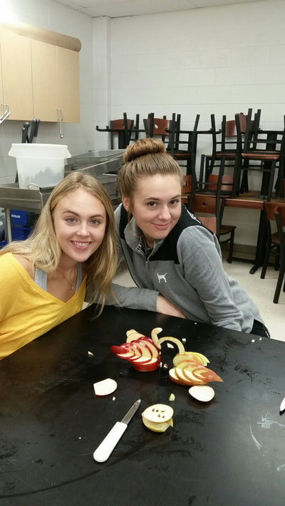 Foods student posing with finished swan.