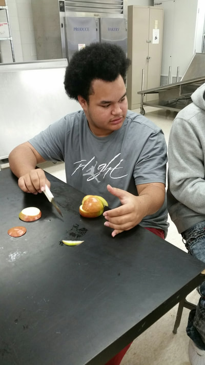 foods student creating an apple swan. 