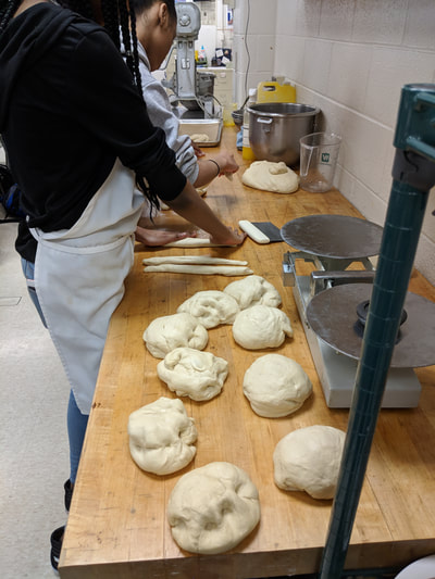 Students creating bread dough balls for students to use to create bread animals.  