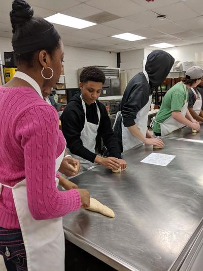 Students rolling bread.