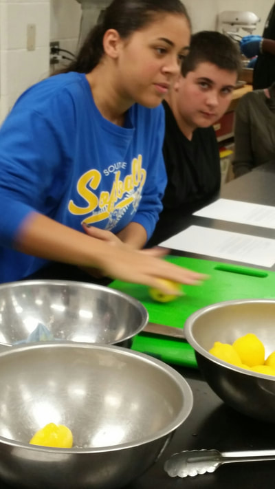 Student cutting lemons for hummus.