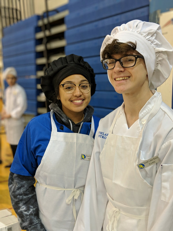 two student chefs posing for a picture