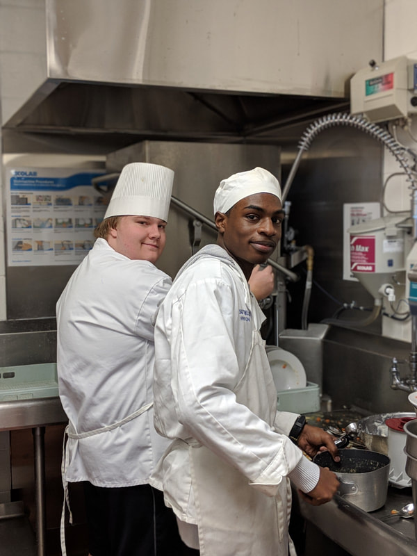 Culinary Arts student chefs covering the dishwasher area hard at work