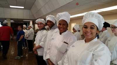 Smiling student chefs waiting to serve.