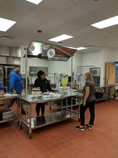 People waiting for refreshments in culinary arts kitchen.