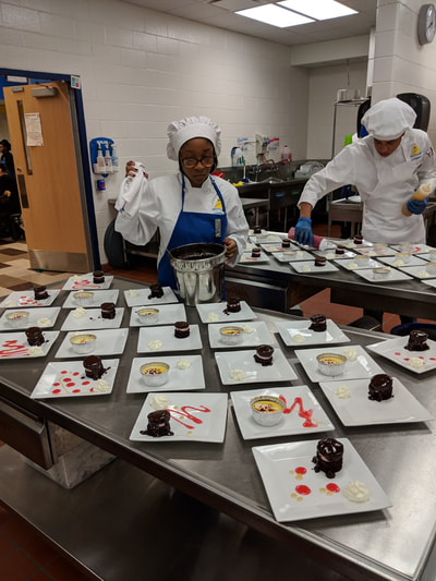 students creating desserts for event