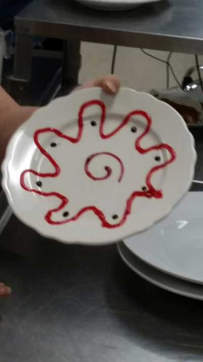 3/4 hr culinary student done decorating plate with strawberry sauce