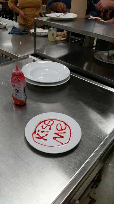 plate decorated with "kiss me" in strawberry sauce.