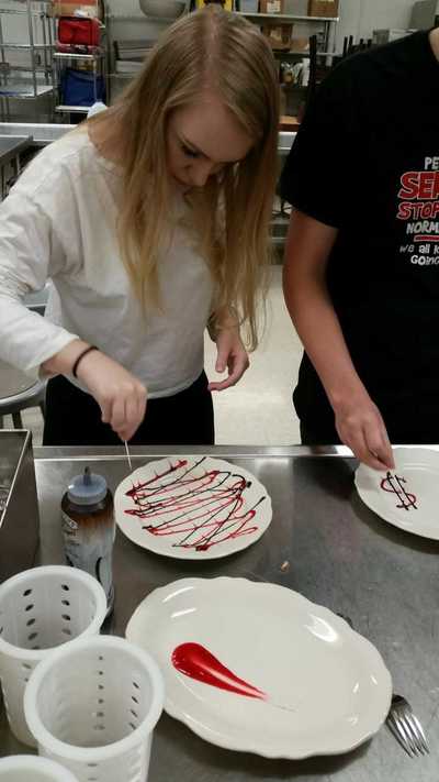 Foods class - plate decorating - criss crossing of chocolate and strawberry sauce