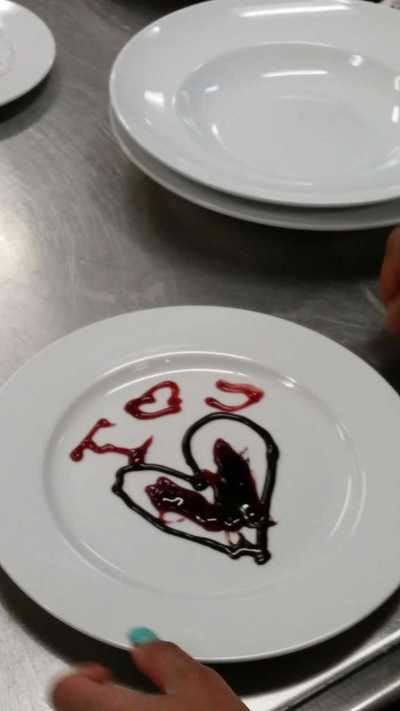 plate decorated with an I love you in strawberry sauce and a chocolate sauce heart