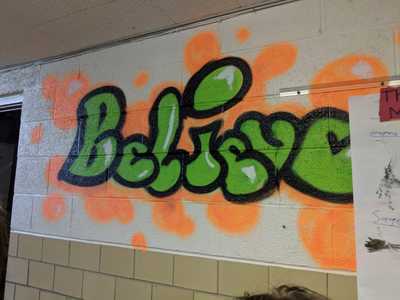Believe mural painted on wall in hallway at Rising Stars Academy. 