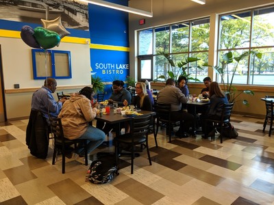 two tables of patrons eating at the student of month lunch