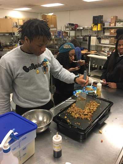 Student cooking fried rice on a griddle.  