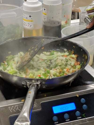 Vegetables cooking in pan to be added to the fried rice.