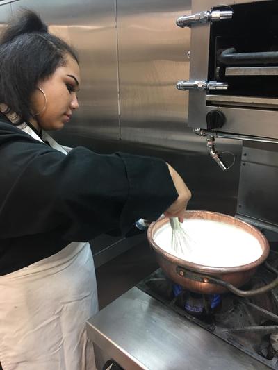 Student using Chef's mom's copper pot to cook on the stove.