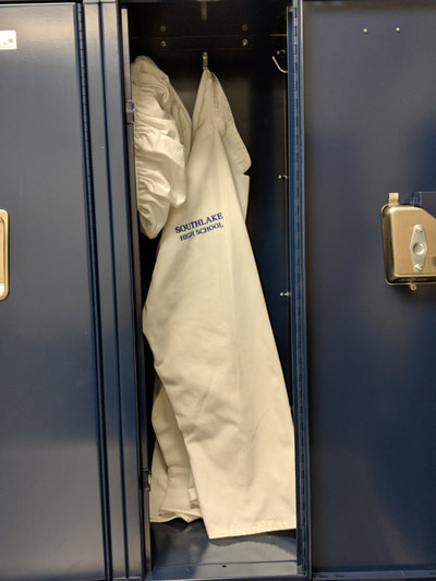 White uniform with hat hanging in lockers in classroom